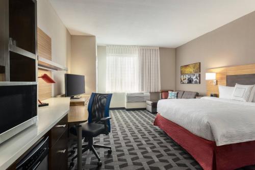 南海文TownePlace Suites by Marriott Memphis Southaven的酒店客房配有一张床和一张书桌及一台电视