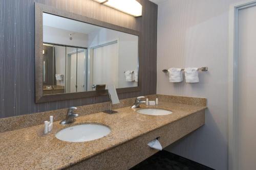 奥尔巴尼Courtyard by Marriott Albany的一间带两个盥洗盆和大镜子的浴室