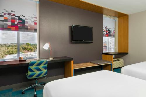 塔拉哈西塔拉哈西市中心雅乐轩酒店的酒店客房设有一张床、一张书桌和一台电视机。
