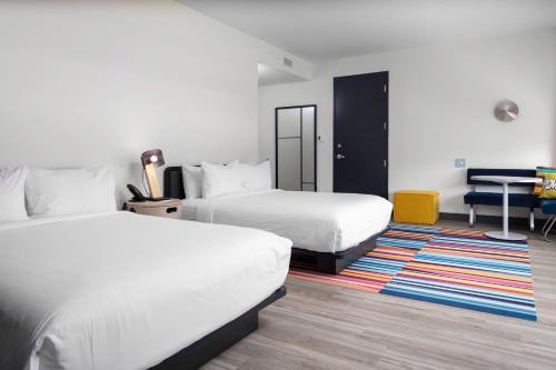 萨凡纳Aloft Savannah Airport的酒店客房配有两张床和一张书桌