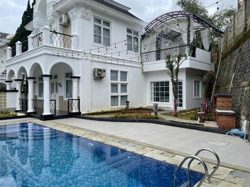 普卡Eton Asia Villas-Kota Bunga的一座白色的房子,前面设有一个游泳池