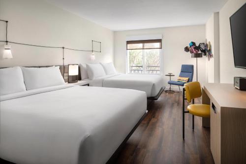 山景城Aloft Mountain View的酒店客房配有两张床和一张书桌