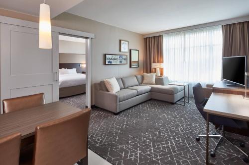 纳什维尔Residence Inn by Marriott Nashville Downtown/Convention Center的酒店客房带沙发以及一间卧室