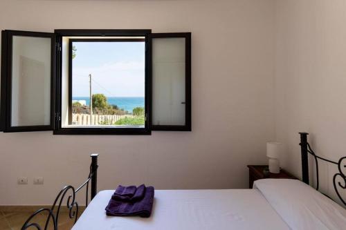 诺托玛丽娜~ Villa Demetra ~的一间卧室设有两张床和窗户。