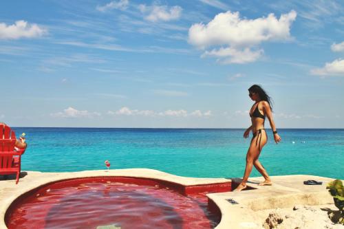 科苏梅尔Hotel B Cozumel的一位在游泳池旁走着比基尼的女人