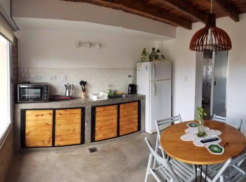 卡法亚特Malvón的厨房配有木桌和白色冰箱。