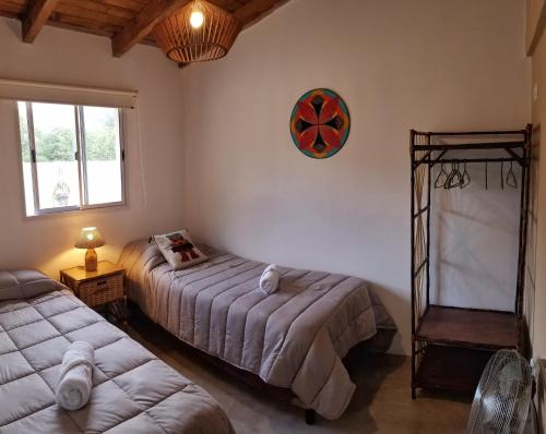 卡法亚特Malvón的一间卧室设有两张床,墙上挂着一个时钟。