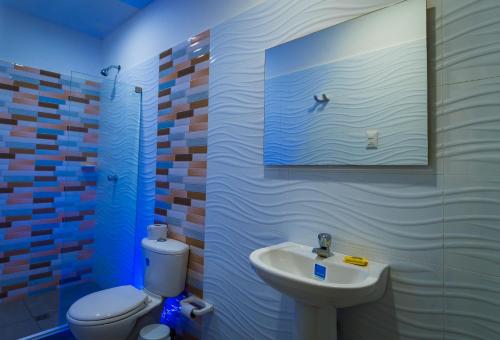 辛塞莱霍Genesis Hotel的一间带水槽、卫生间和镜子的浴室