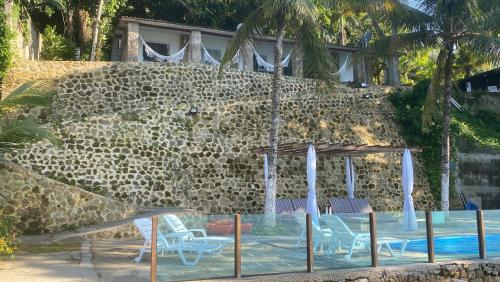 安格拉杜斯雷斯Vivalavida Serra&Mar的一个带椅子和石墙的游泳池