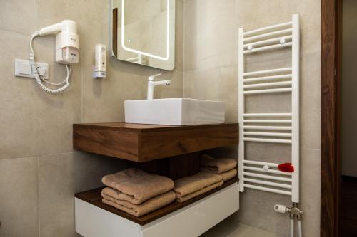 MaglajEdemus - Motel & Restaurant的浴室配有盥洗盆、镜子和毛巾