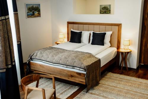 MaglajEdemus - Motel & Restaurant的一间卧室配有床和两张桌子及椅子