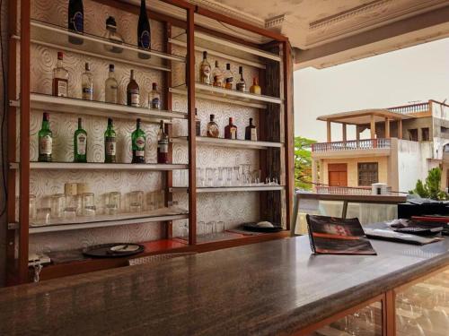 科托努HÔTEL NOAHGARDEN 2的墙上装有瓶子和眼镜的酒吧