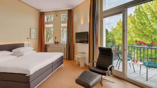 波恩Rheinhotel Dreesen的酒店客房设有一张床和一个阳台。