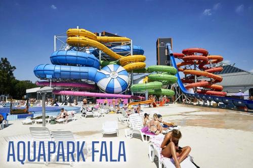 罗兹Lodz4u - Premium Apartments - MANUFAKTURA - Garaż - Wiosna 2024的海滩上带水滑梯的水上公园