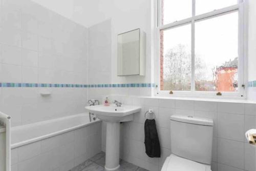 齐格威尔Luxury 2 BD, 2 BA on private gated Chigwell park的白色的浴室设有水槽、卫生间和窗户。