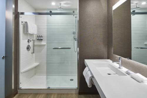 亚特兰大AC Hotel by Marriott Atlanta Airport Gateway的一间带玻璃淋浴和水槽的浴室