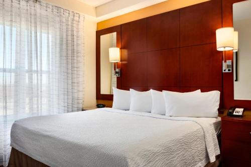 格林斯伯勒Residence Inn by Marriott Greensboro Airport的酒店客房带一张大床,带白色床单