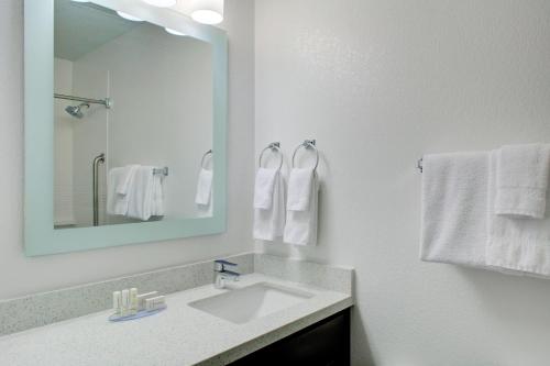 威奇托东威奇托图尼帕拉斯套房酒店的浴室配有盥洗盆、镜子和毛巾
