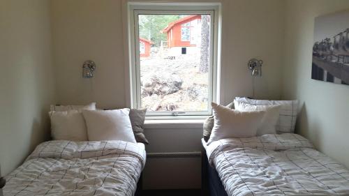 MonSkärgårdsbyn S:t Anna的两张床位于带窗户的房间内