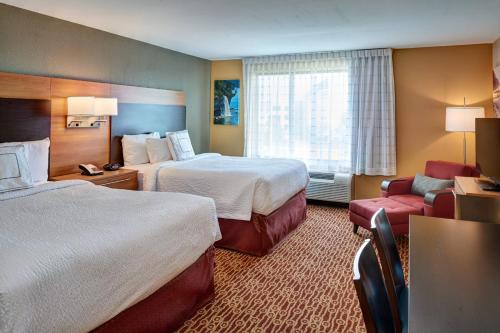 特洛伊底特律特洛伊万豪广场套房酒店的酒店客房,配有两张床和椅子