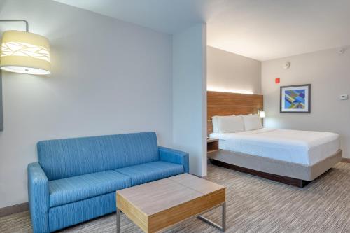 TroyHoliday Inn Express Troy, an IHG Hotel的酒店客房,配有床和蓝色的沙发