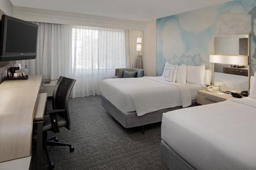 休斯顿休斯顿威斯特契斯万怡酒店的酒店客房配有两张床和一张书桌
