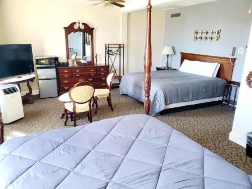 Monte VistaMonte Villa Hotel的一间卧室配有一张床、一张书桌和一台电视