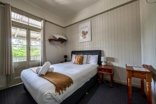Yandina燕地那酒店的一间卧室配有一张床、一张桌子和一个窗户。