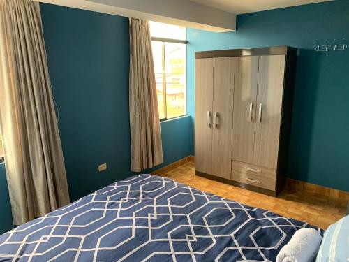 库斯科El Viejo Roble的一间拥有蓝色墙壁的卧室、一张床和橱柜