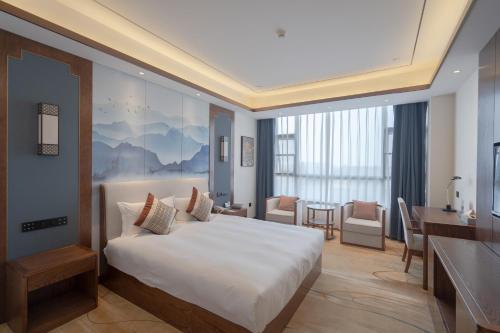 彭泽彭泽远洲轩廷酒店的配有一张床和一张书桌的酒店客房