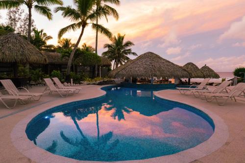 拉罗汤加Club Raro Resort- Adults Only的一个带椅子和棕榈树的度假村游泳池
