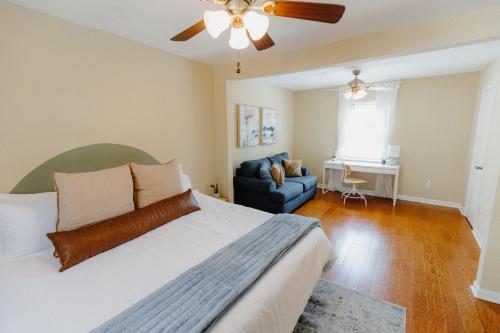 孟菲斯Centrally Located 3BR Overton Square Fast WiFi Free Parking Yes Pets的一间卧室配有一张床、一张沙发和吊扇。