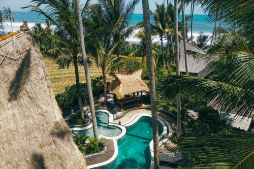 塔巴南Most Exotic Villa Keong Tabanan的享有棕榈树度假村游泳池的空中景致