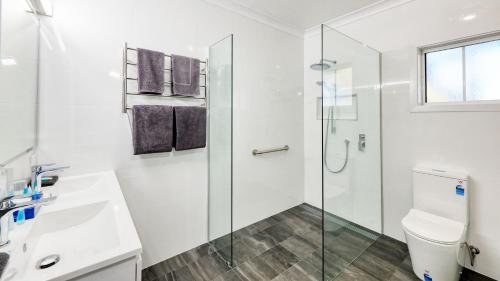 扬Colonial Motel & Apartments的一间带玻璃淋浴和卫生间的浴室