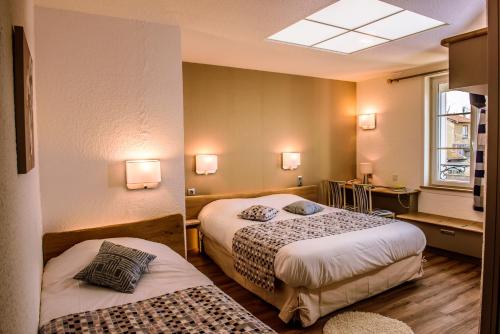 圣梅内乌勒Logis Le Cheval Rouge的酒店客房设有两张床和窗户。