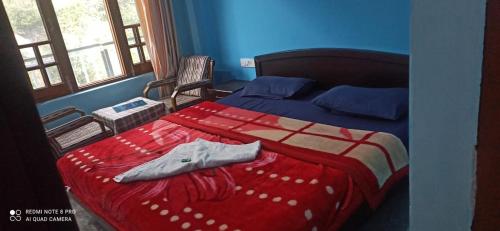 达兰萨拉Mountain and Moon, Dharamkot的一间卧室配有一张带红白毯子的床