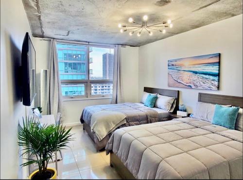 迈阿密Platinum 2BD 2BTH at Midblock的一间卧室设有两张床和窗户。