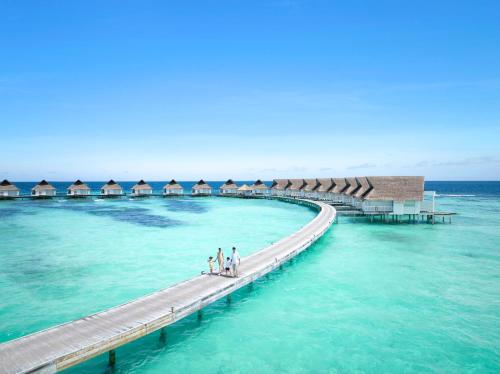 MachchafushiCentara Grand Island Resort & Spa的海上的码头,有人在上面行走