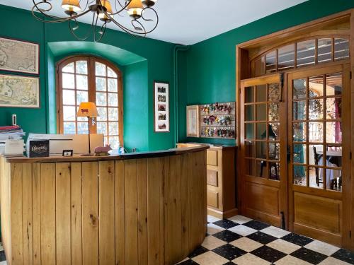 奥布拉克La Domerie - Maison d'hôtes的一间拥有绿色墙壁和木柜台的商店