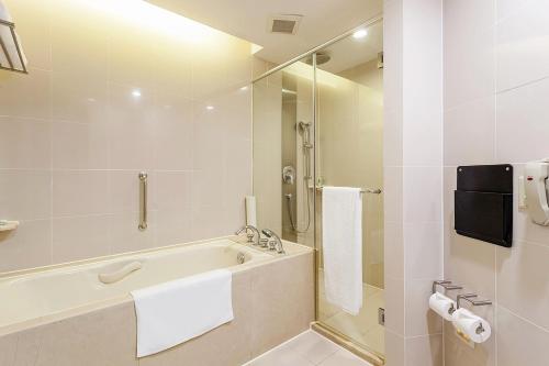 上海上海古井假日酒店的白色的浴室设有浴缸和淋浴。
