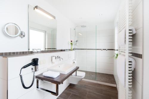 加尔布森布鲁迪克餐厅酒店的白色的浴室设有水槽和卫生间。