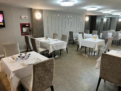 蒂米什瓦拉德派克酒店的一间设有白色桌椅的用餐室