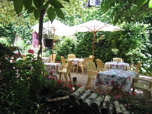 克卢尼勃艮第酒店的花园配有桌椅和遮阳伞。