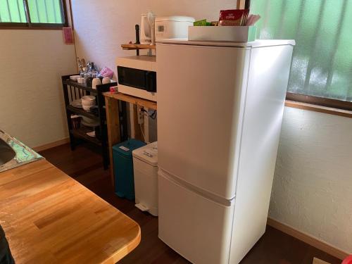 奄美Yamato inn - Vacation STAY 86368v的厨房配有白色冰箱,配有微波炉
