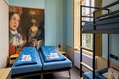 东卡佩勒Stayokay Hostel Domburg的一间设有双层床的房间和一幅女画