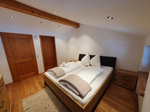 施莱兴Gasthof Zellerwand的一间卧室配有带白色床单和枕头的床。