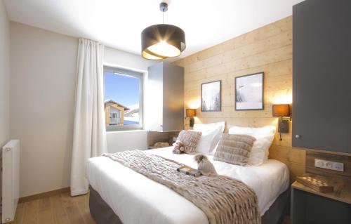 拉普德兹Appart'Hôtel Prestige Odalys L'Eclose的卧室设有一张白色大床和一扇窗户。