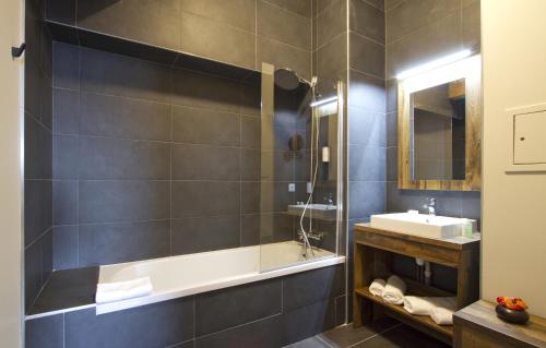 拉普德兹Appart'Hôtel Prestige Odalys L'Eclose的带浴缸和盥洗盆的浴室