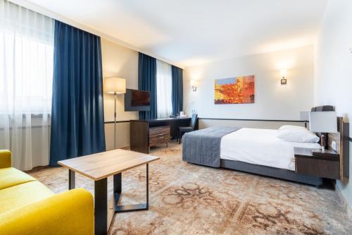 凯尔采Qubus酒店的配有一张床和一张书桌的酒店客房