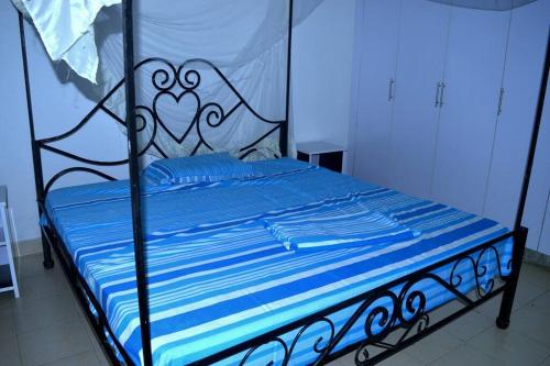 布琼布拉Bujumbura Sweet Home - Maison bien équipée avec voiture gratuite的一张带蓝色床单和黑白床架的床